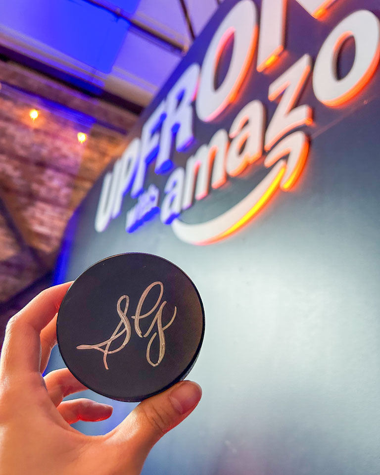Hand holding a personalized compact engraved with calligraphy initials “SG” at Amazon’s Upfront event in Toronto, created live on-site by JW Lettering calligrapher Jessie Wang.