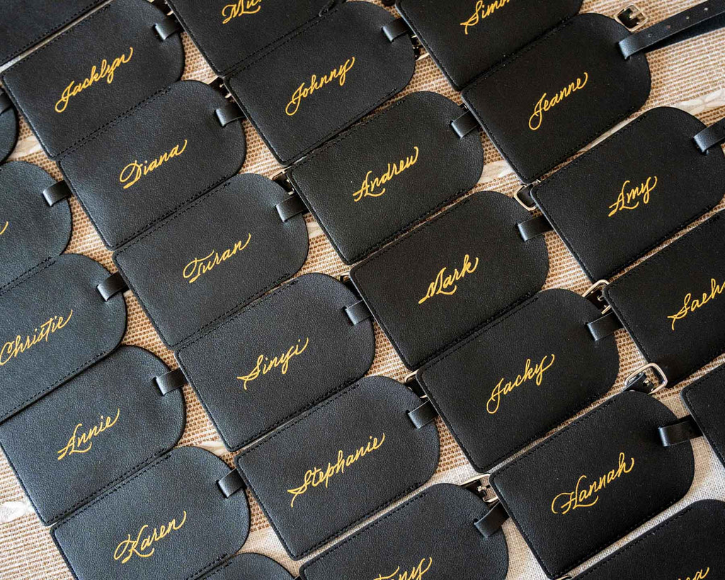 Set of personalized leather luggage tags with guests’ names foiled in gold by JW Lettering in Toronto for an event personalization project.