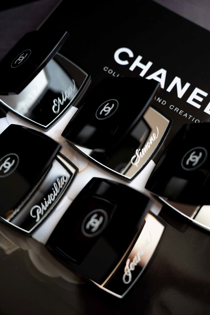 Toronto engraving artist personalizing Chanel makeup compacts with hand-engraved calligraphy names.