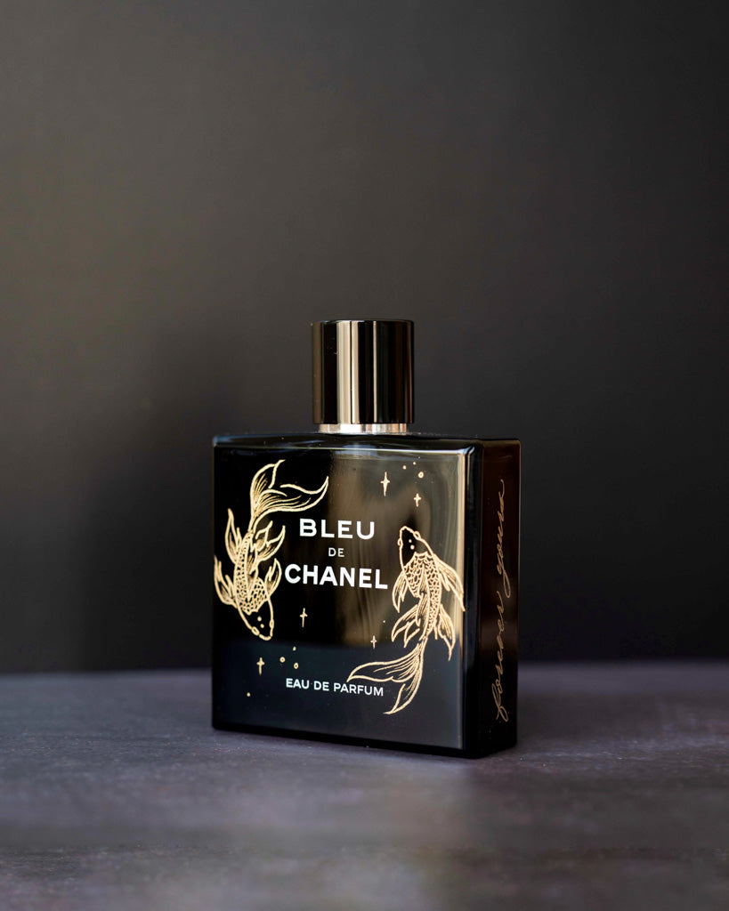 Toronto artist hand engraved gold koi fish illustration on Bleu de Chanel perfume bottle for luxury gift.