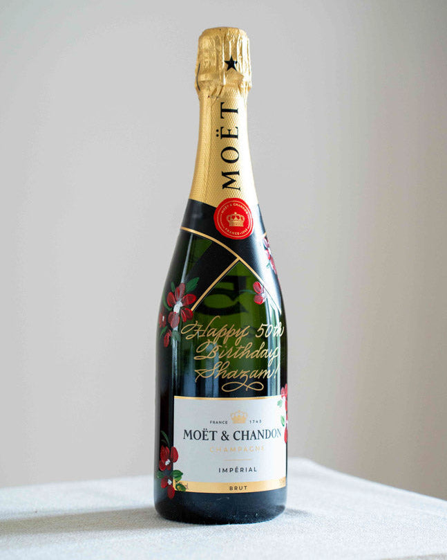 Custom Moët & Chandon champagne bottle with red floral painting and gold calligraphy message by Toronto artist.