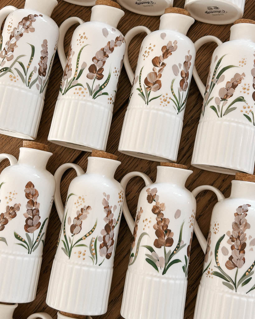 Muted lavender florals hand-painted ceramic bottles designed as personalized wedding favors for Toronto couples.