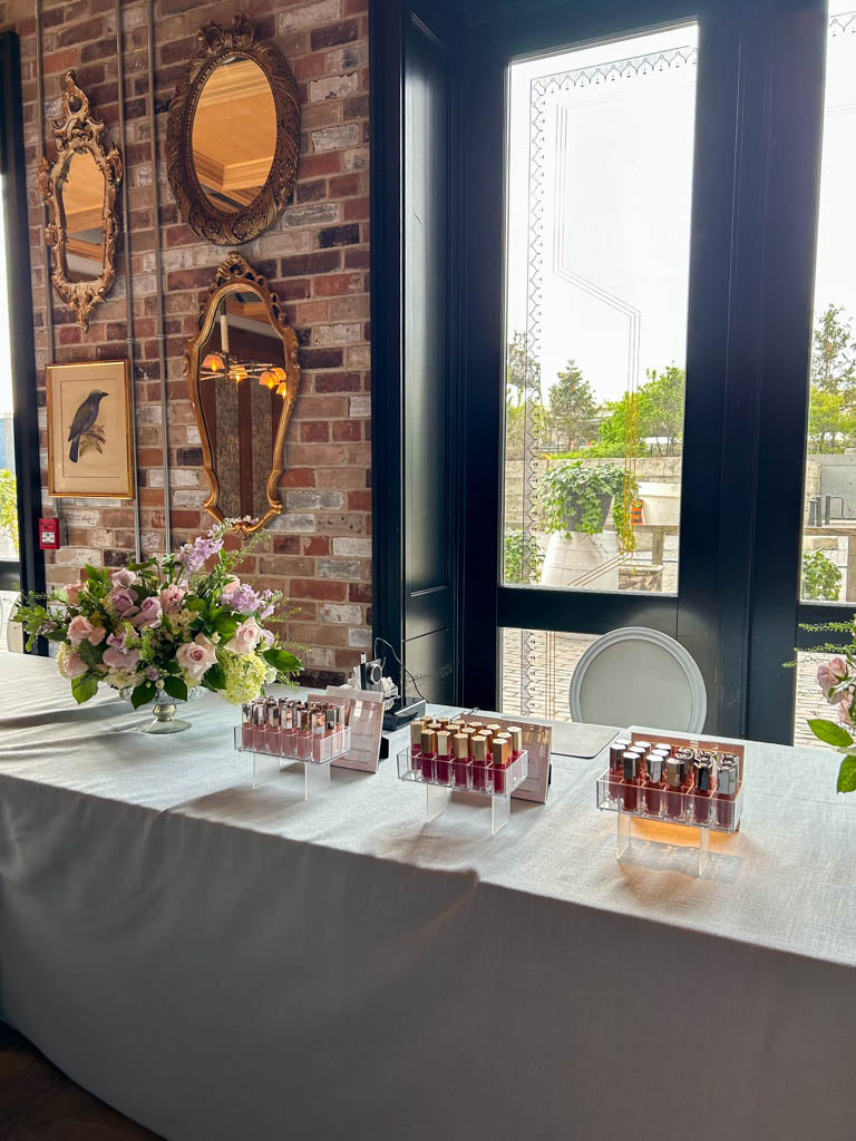 Event engraving setup with lipsticks and floral decor in Toronto for a unique bridal shower gifting experience.