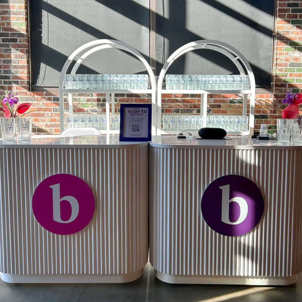 Live engraving station at Beazley Toronto corporate event featuring branded bar counters and glass display.